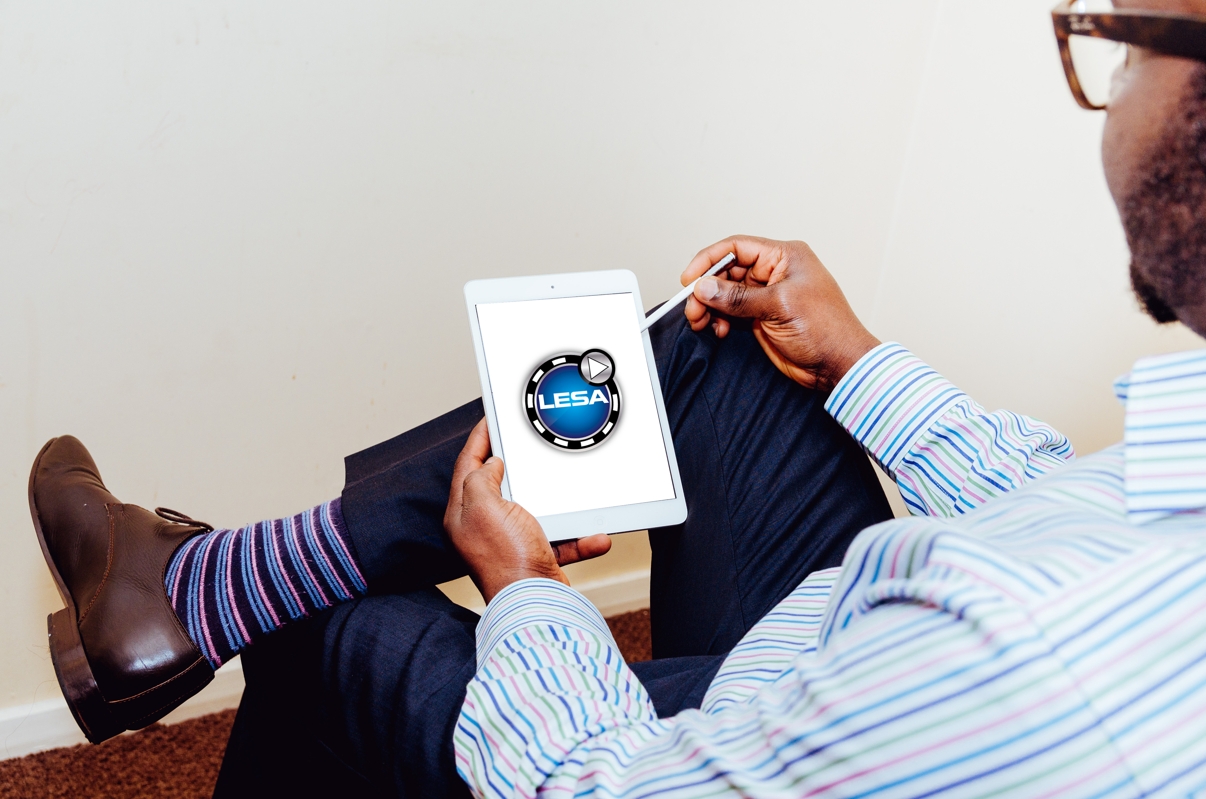 Man looking at a tablet with LESA logo